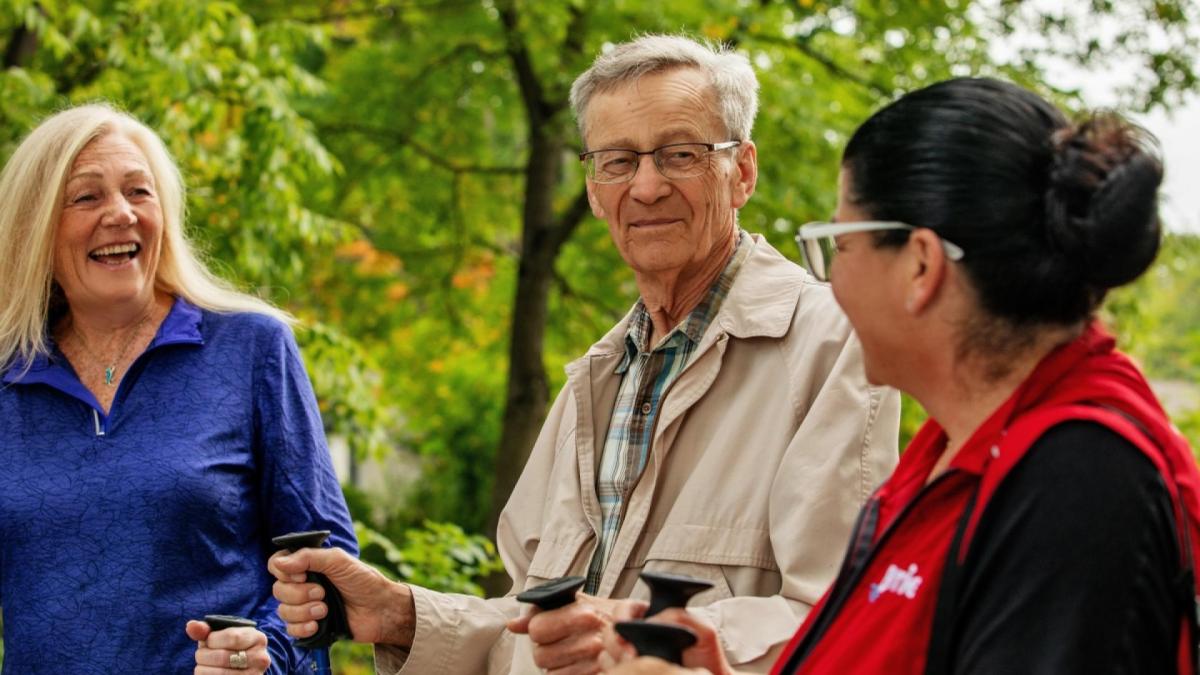 Older adults smiling, trees in background