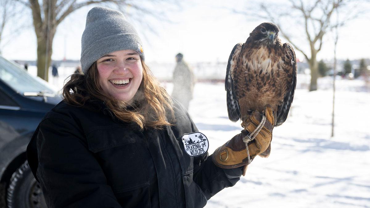 Person holding a large bird.