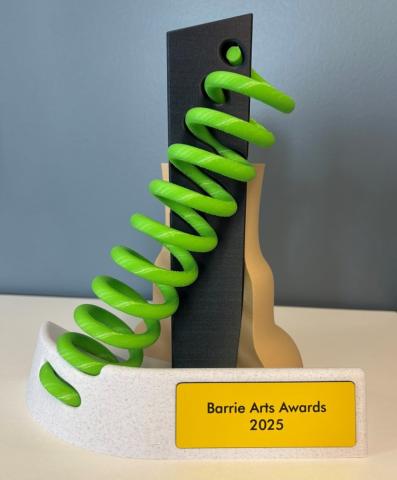 A colourful award featuring a green spiral element with a gray and white base, labeled "Barrie Arts Awards 2025."