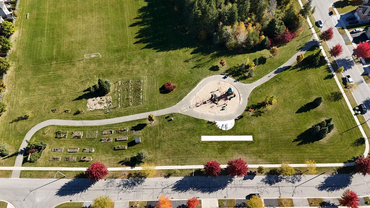 Aerial view of a park with a community garden, playground equipment and fitness circuit
